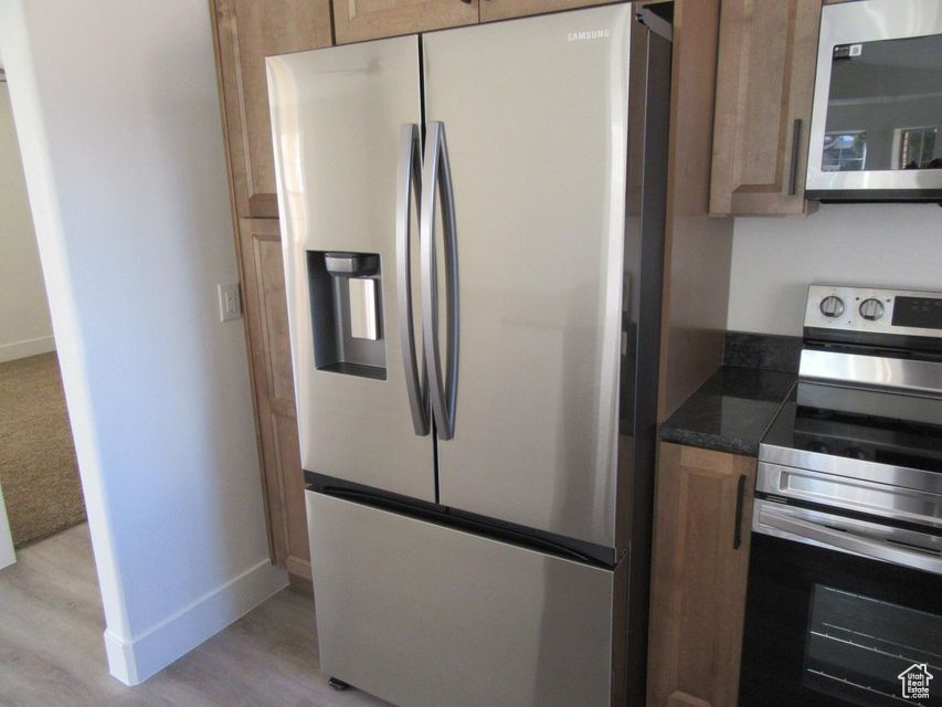 Kitchen featuring stainless steel appliances and light hardwood / wood-style floors