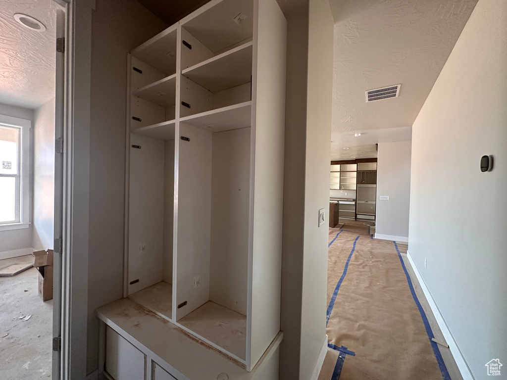 Mudroom featuring a textured ceiling and baseboards