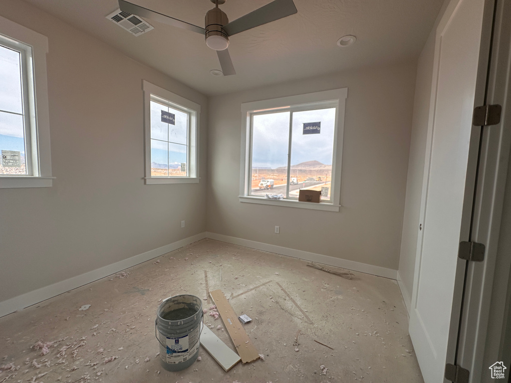 Empty room with ceiling fan and baseboards