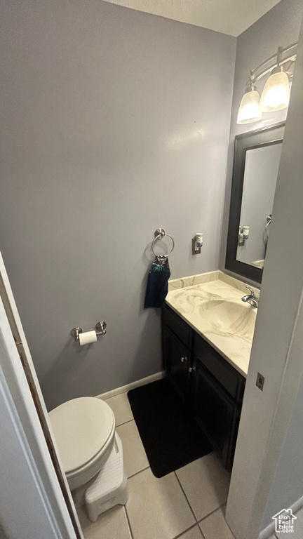 Bathroom with vanity, tile patterned floors, and toilet