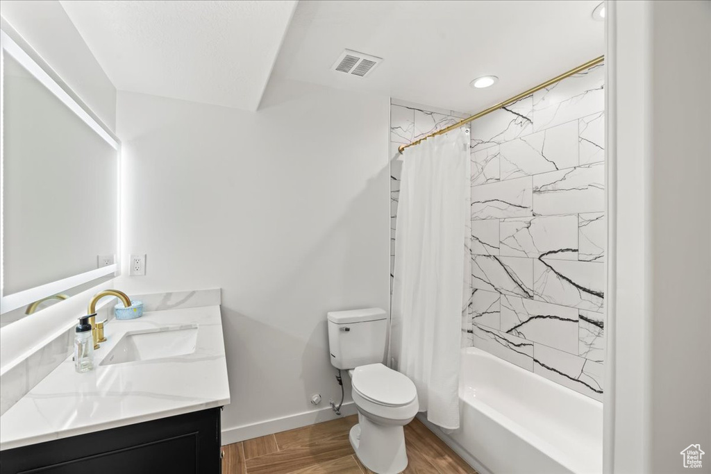 Full bathroom featuring vanity, shower / tub combo, and toilet