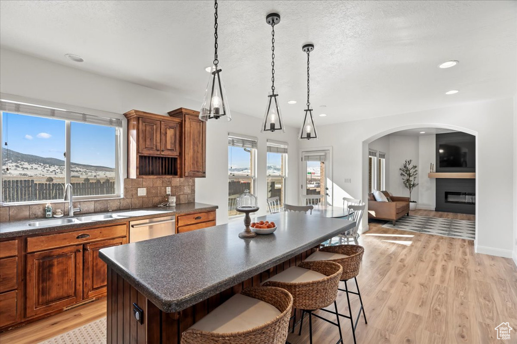 Kitchen featuring sink, a center island, a kitchen bar, decorative backsplash, and stainless steel dishwasher