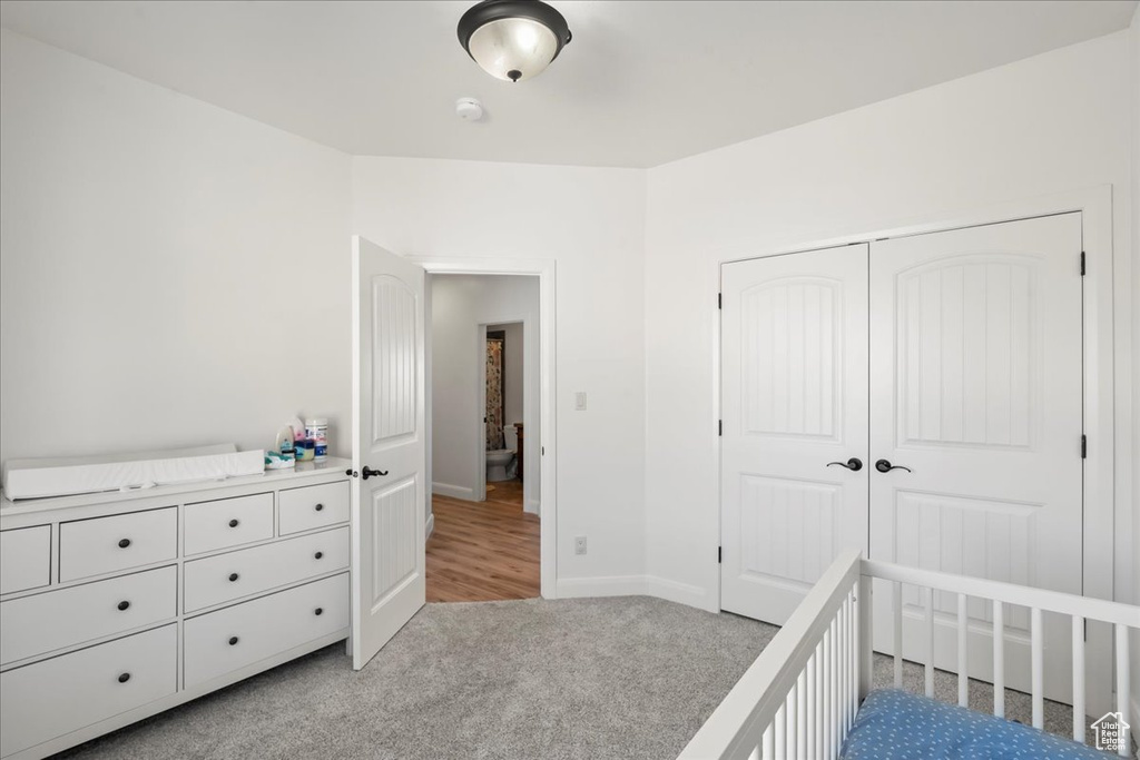 Unfurnished bedroom featuring light colored carpet and a closet