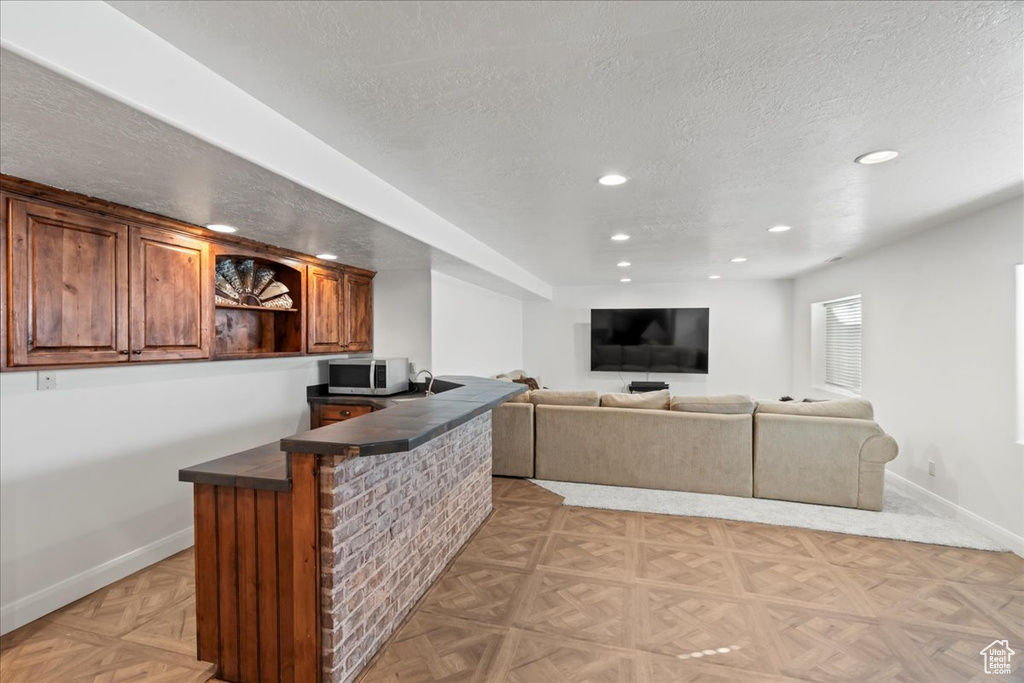 Bar featuring a textured ceiling and light parquet floors