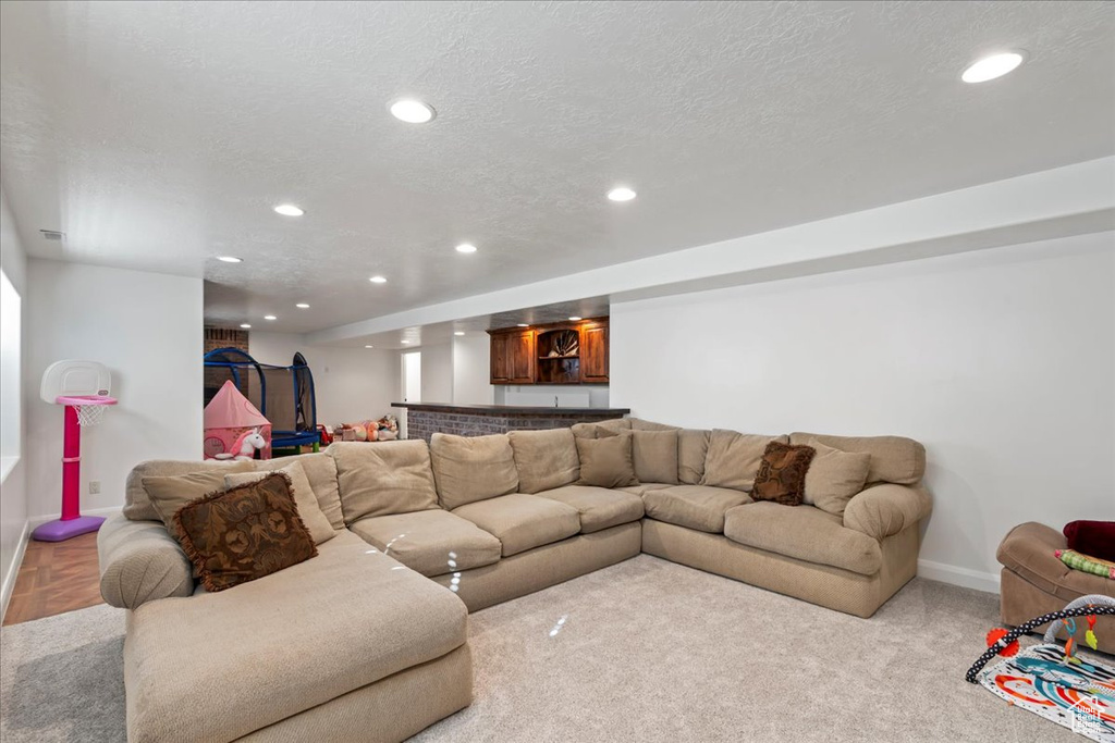 Carpeted living room with a textured ceiling