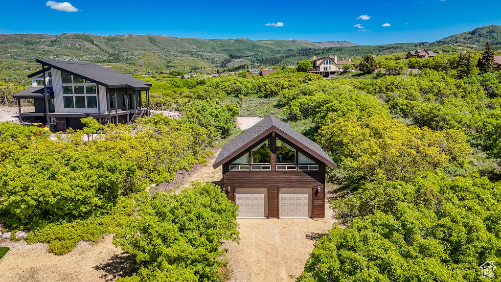 Aerial view of property and surrounding area with a mountainous background