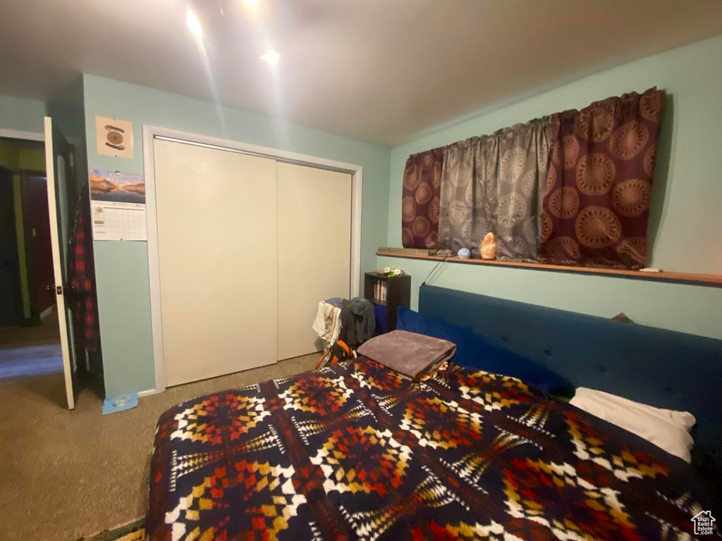 Carpeted bedroom featuring a closet