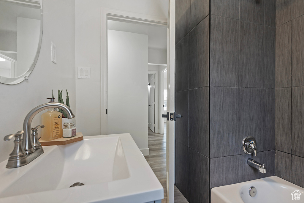 Bathroom featuring vanity, hardwood / wood-style floors, and tub / shower combination