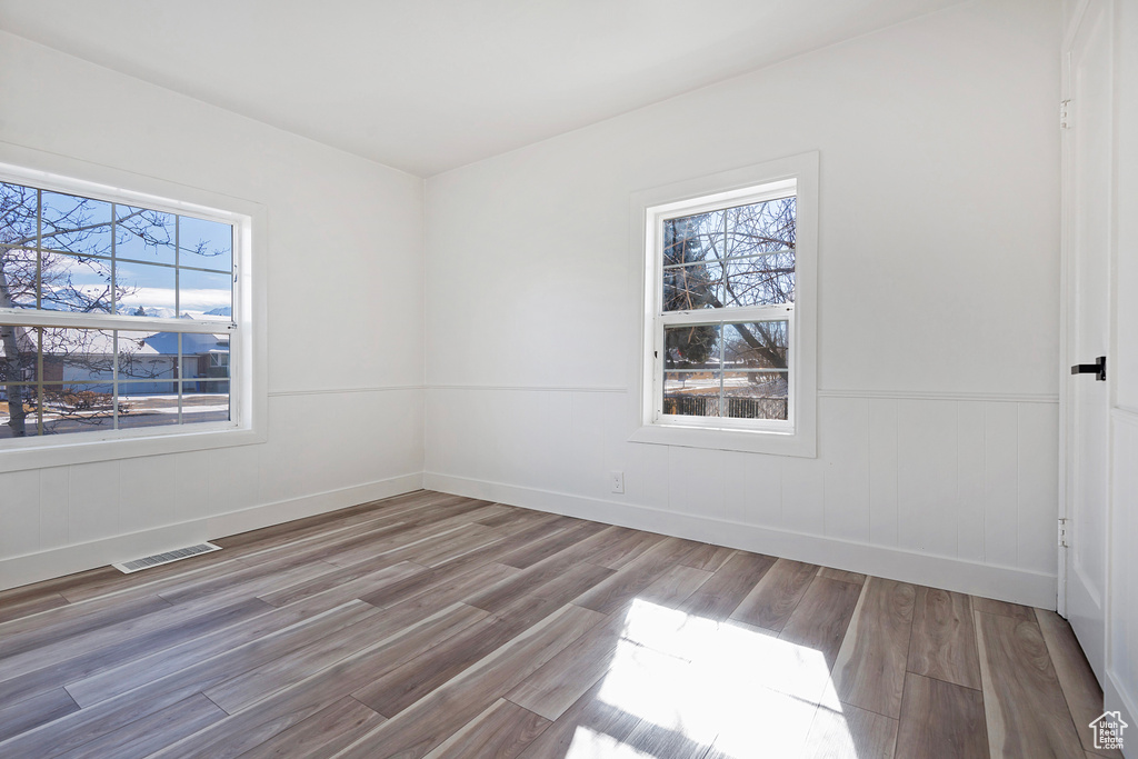 Unfurnished room with hardwood / wood-style floors and a wealth of natural light