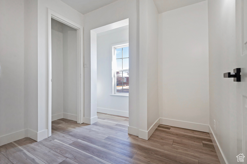 Corridor with light hardwood / wood-style flooring