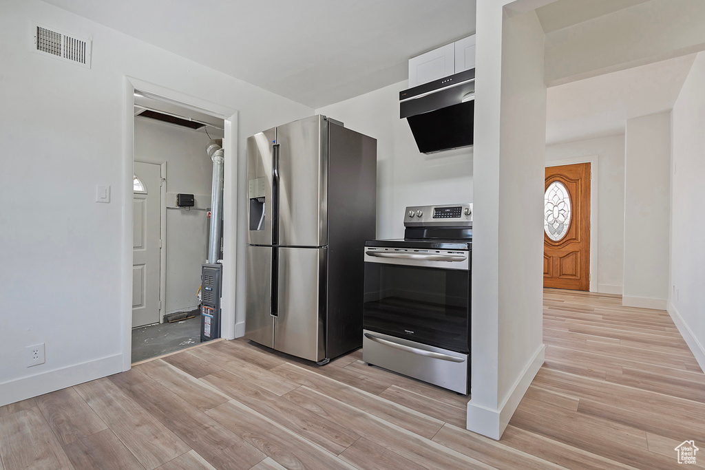 Kitchen featuring white cabinetry, light hardwood / wood-style flooring, and stainless steel appliances