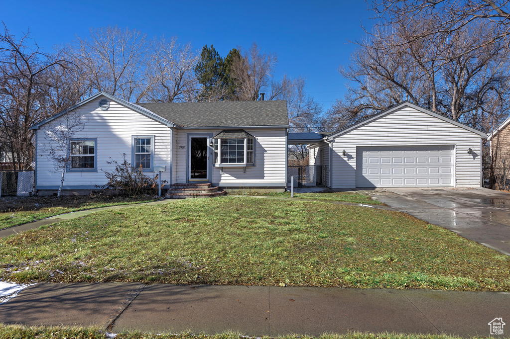 Single story home featuring a garage and a front yard