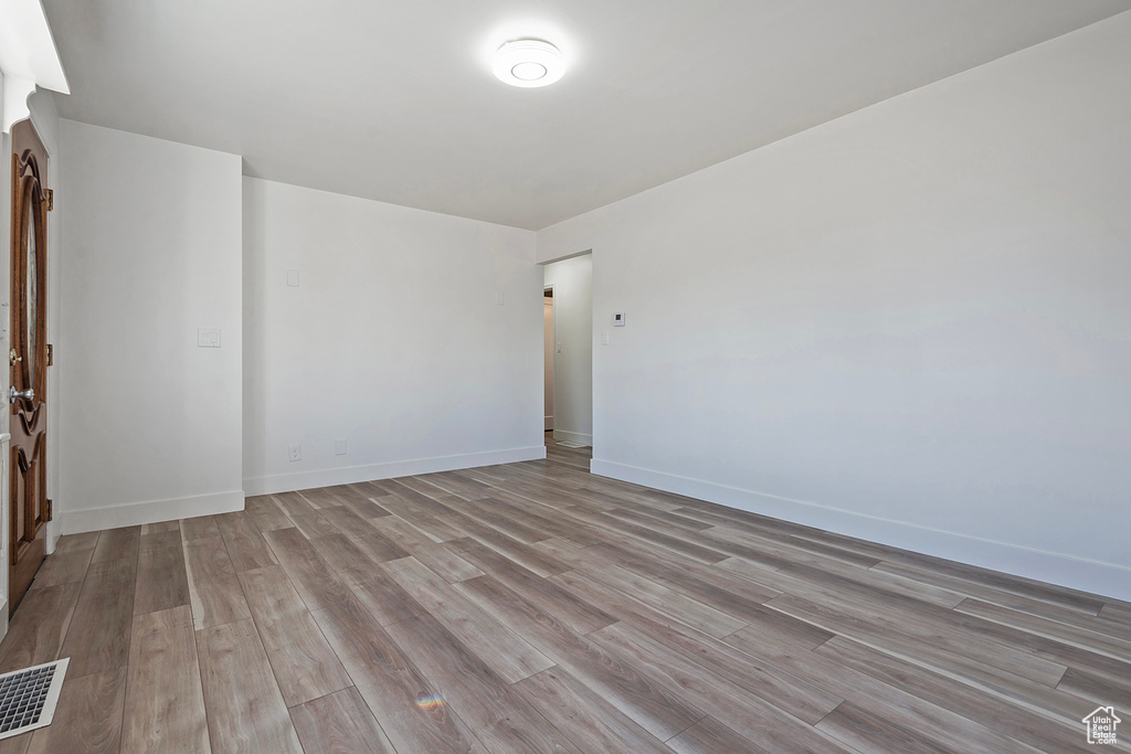 Empty room with light hardwood / wood-style flooring