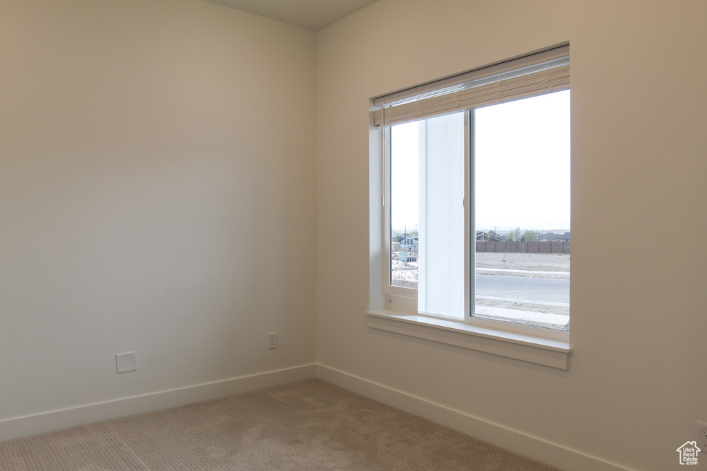 Spare room featuring baseboards and carpet floors