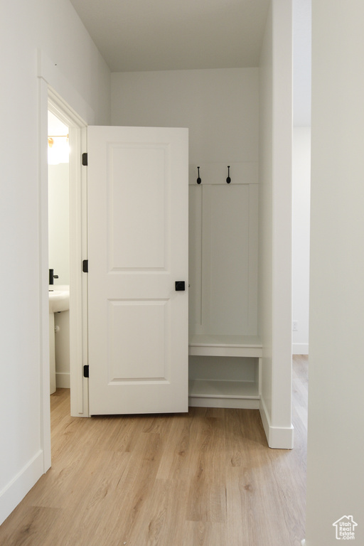 Mudroom featuring light wood-style floors and baseboards