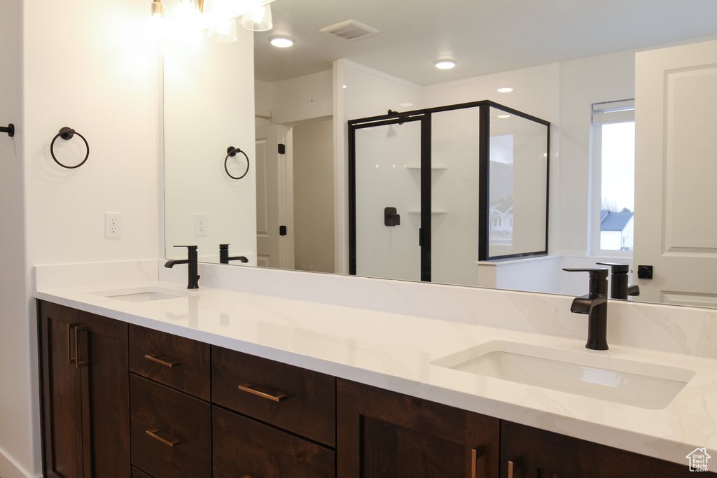 Full bathroom featuring double vanity and a stall shower