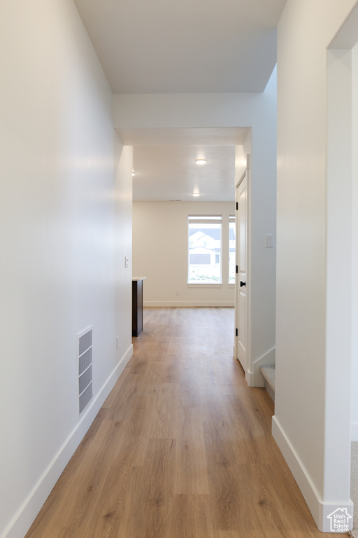 Hallway with light wood finished floors and baseboards