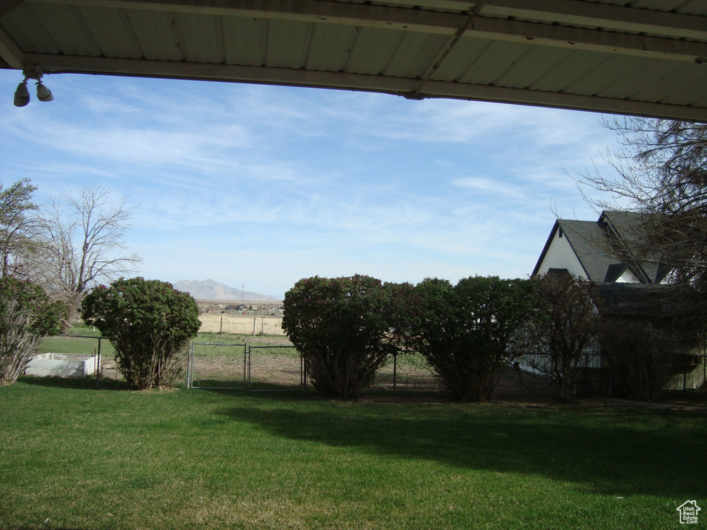 View of yard with a mountain view and fence