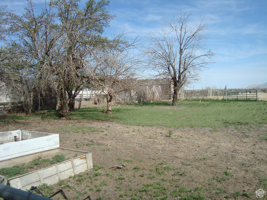View of yard featuring fence, an outdoor structure, and a barn