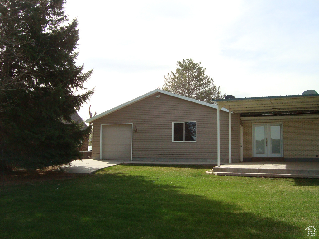Exterior space with french doors, a yard, and driveway
