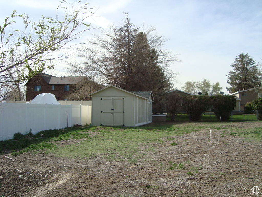 View of yard featuring a storage shed, an outdoor structure, and fence private yard