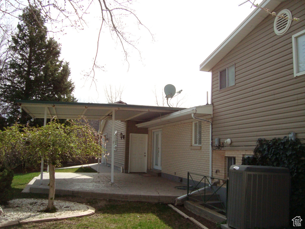 Rear view of house featuring cooling unit and a patio area