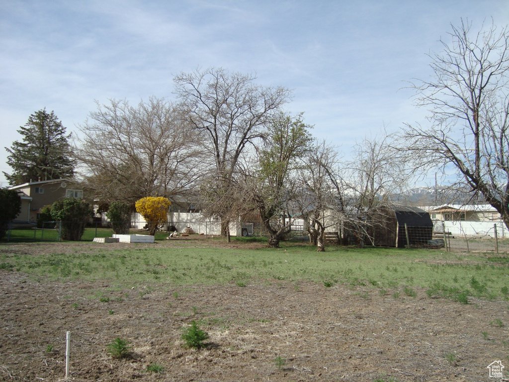 View of yard featuring fence and an outbuilding
