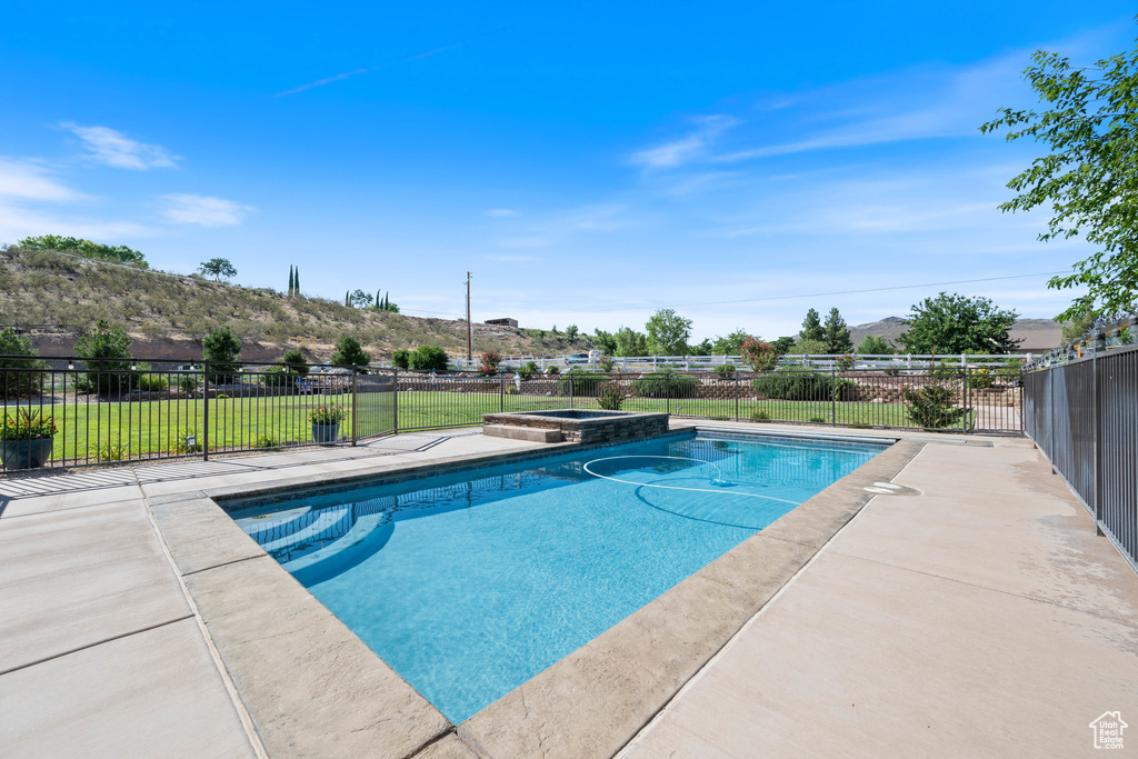 View of swimming pool with a mountain view, a pool with connected hot tub, and a patio area