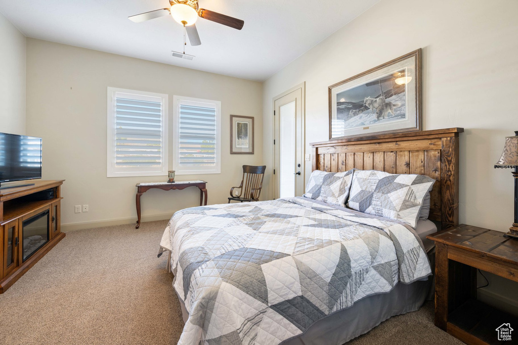 Carpeted bedroom with a ceiling fan and baseboards