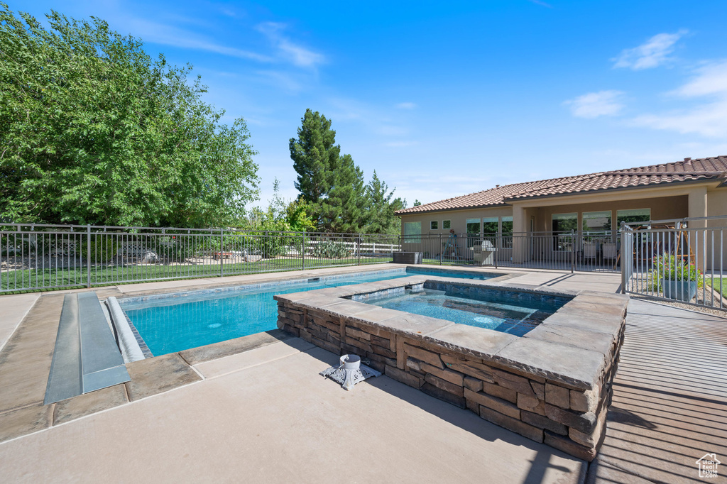 View of pool with an in-ground hot tub and a patio area
