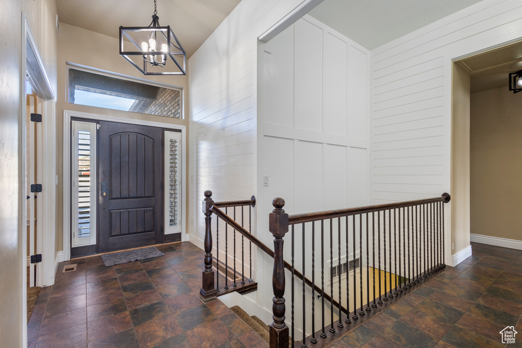 Entryway featuring an inviting chandelier and wood walls