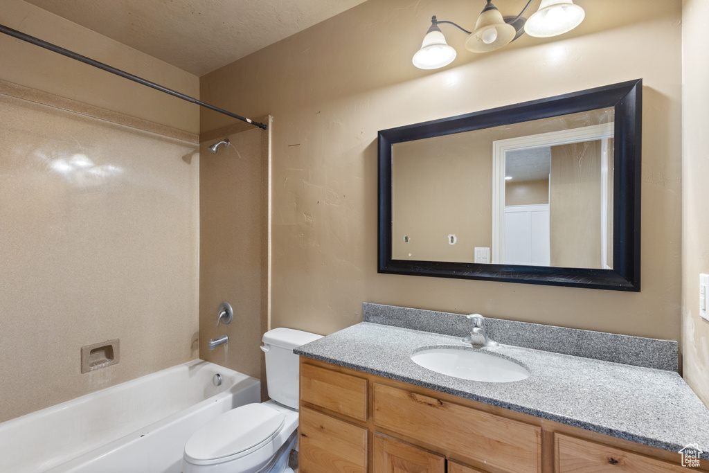 Full bathroom with vanity, tiled shower / bath combo, and toilet