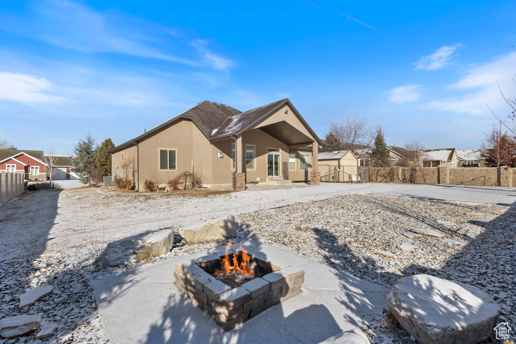 Back of house with a shed and a fire pit