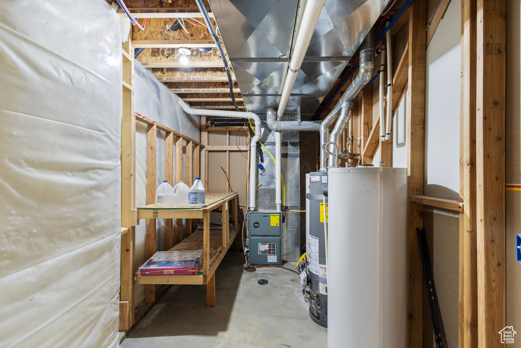 Utilities featuring water heater, heating unit, and strapped water heater