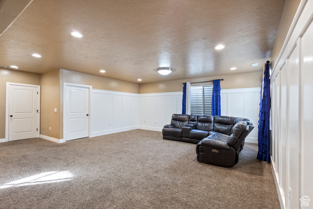 Carpeted living room featuring a textured ceiling