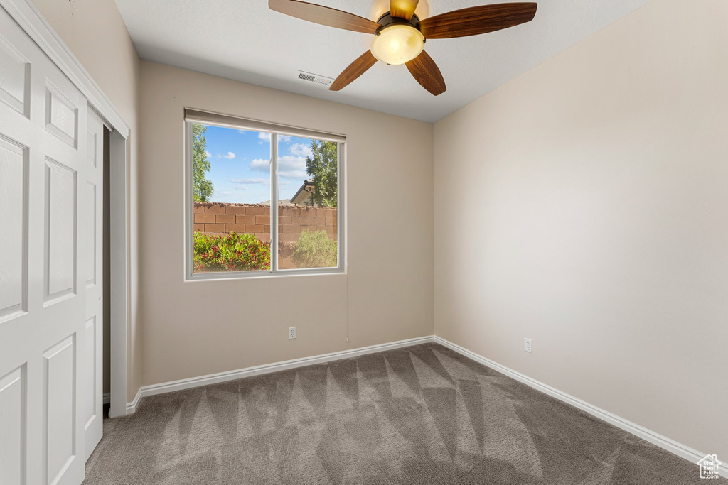Unfurnished bedroom featuring carpet flooring, baseboards, ceiling fan, and a closet