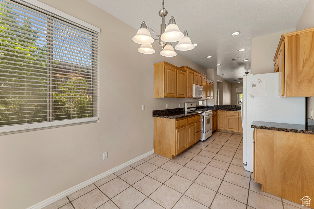 Kitchen featuring white appliances, light tile patterned floors, a chandelier, recessed lighting, and baseboards