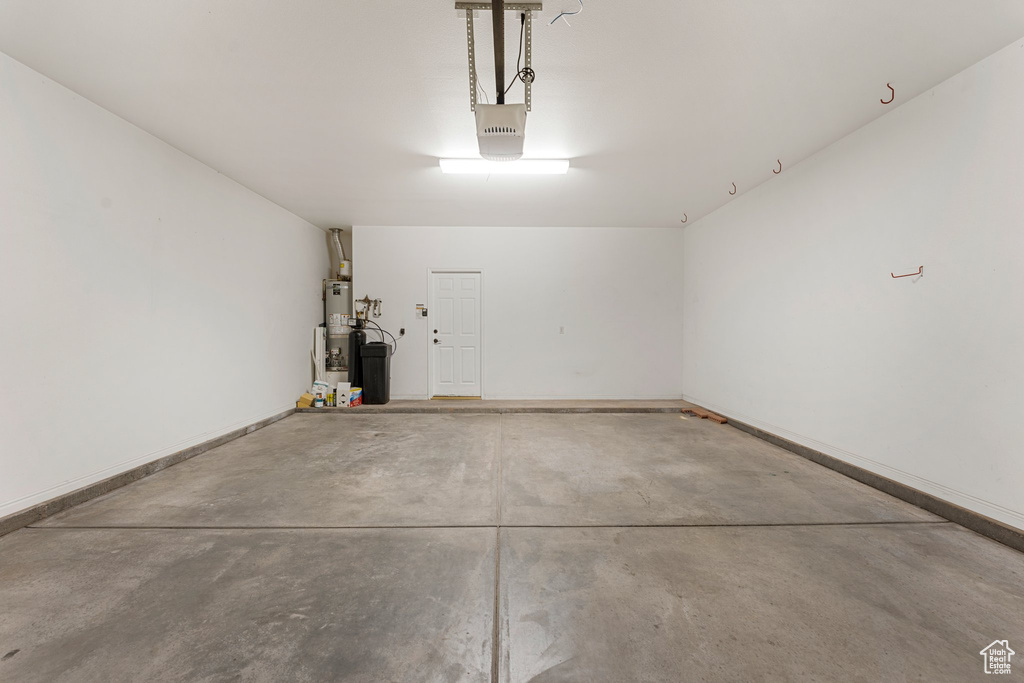 Garage featuring water heater and a garage door opener