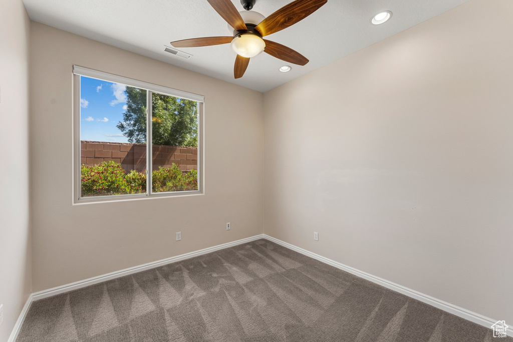Unfurnished room with dark carpet, a ceiling fan, baseboards, and recessed lighting