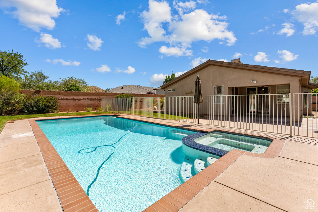 View of swimming pool featuring a pool with connected hot tub and a patio area