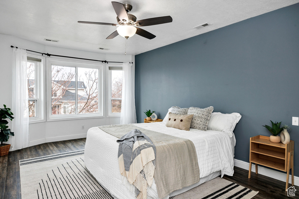 Bedroom featuring ceiling fan and dark hardwood / wood-style flooring