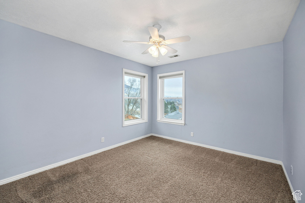 Carpeted spare room with ceiling fan
