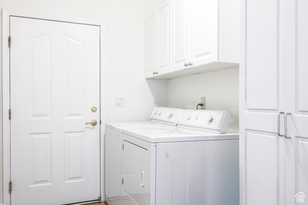 Laundry room featuring cabinets and washing machine and dryer