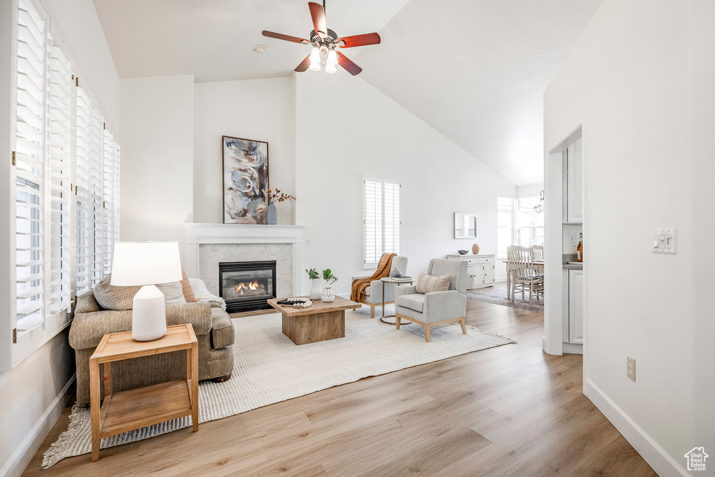 Living room with light hardwood / wood-style flooring, high vaulted ceiling, and ceiling fan