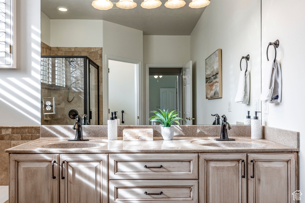 Full bathroom with double vanity and a stall shower