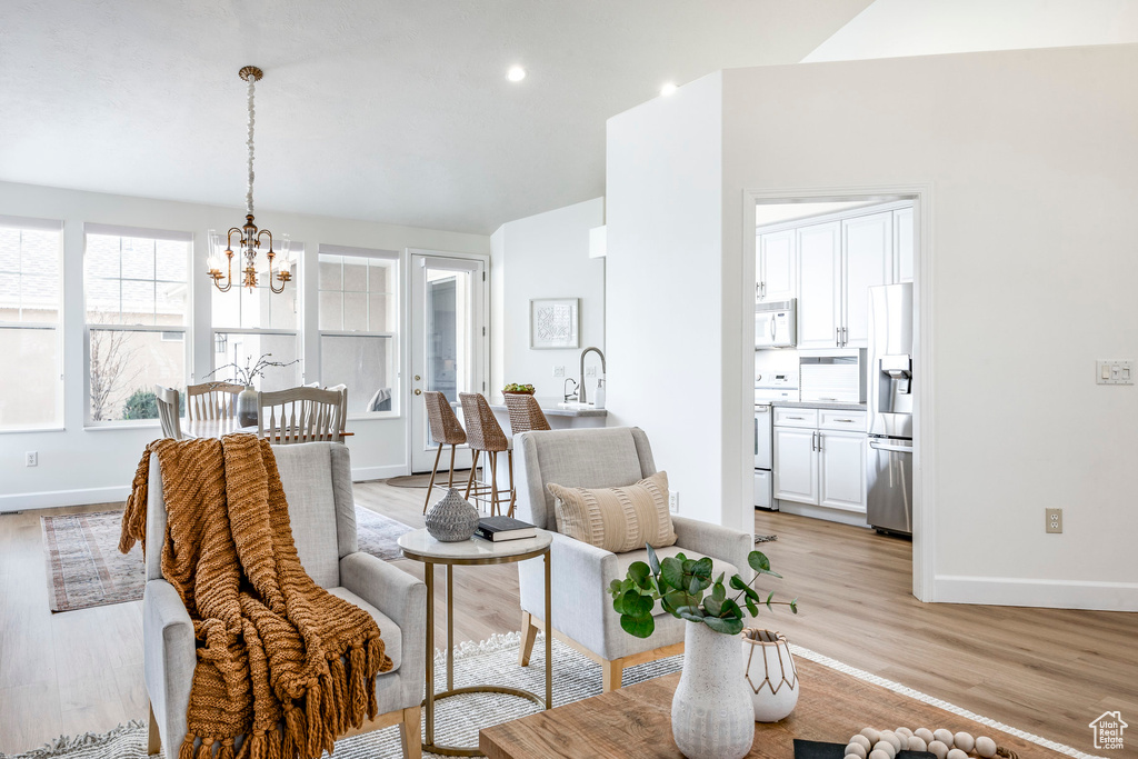 Interior space with an inviting chandelier, sink, and light hardwood / wood-style flooring