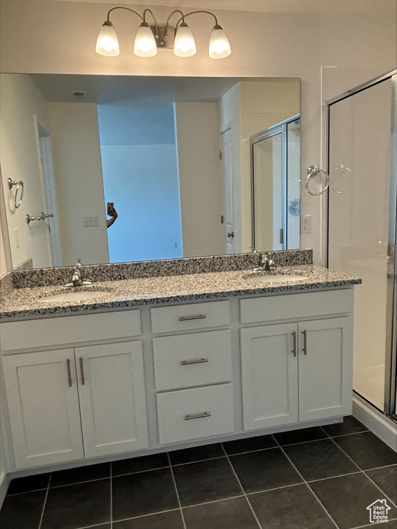 Full bathroom featuring double vanity, tile patterned flooring, and a stall shower
