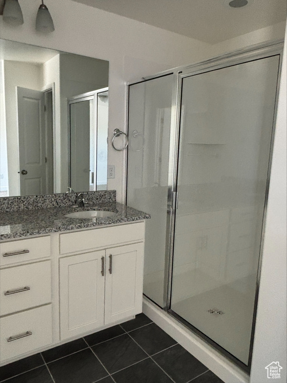Bathroom featuring vanity, a stall shower, and tile patterned floors