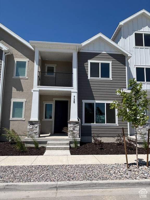 View of property featuring a balcony and board and batten siding