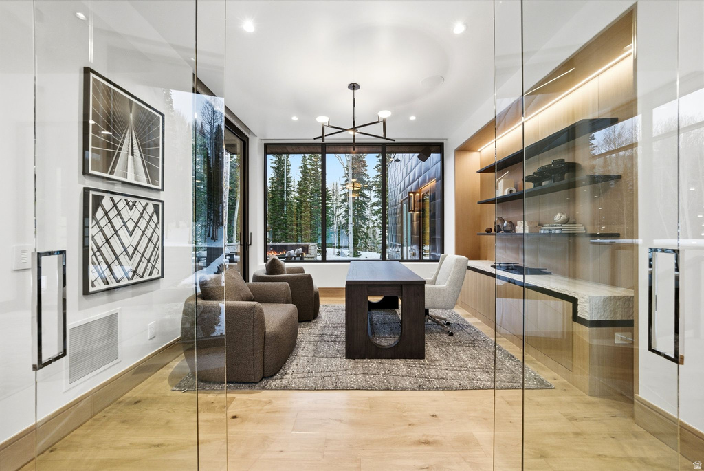 Living room with a chandelier, recessed lighting, and light wood finished floors